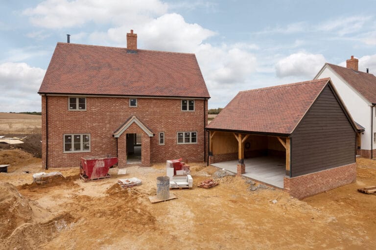 New brick house under construction in countryside setting.