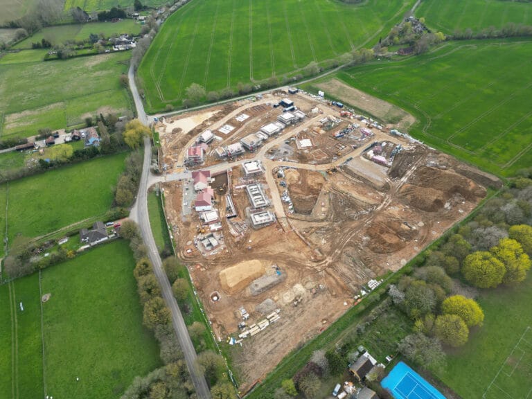 Aerial view of construction site amidst green fields.